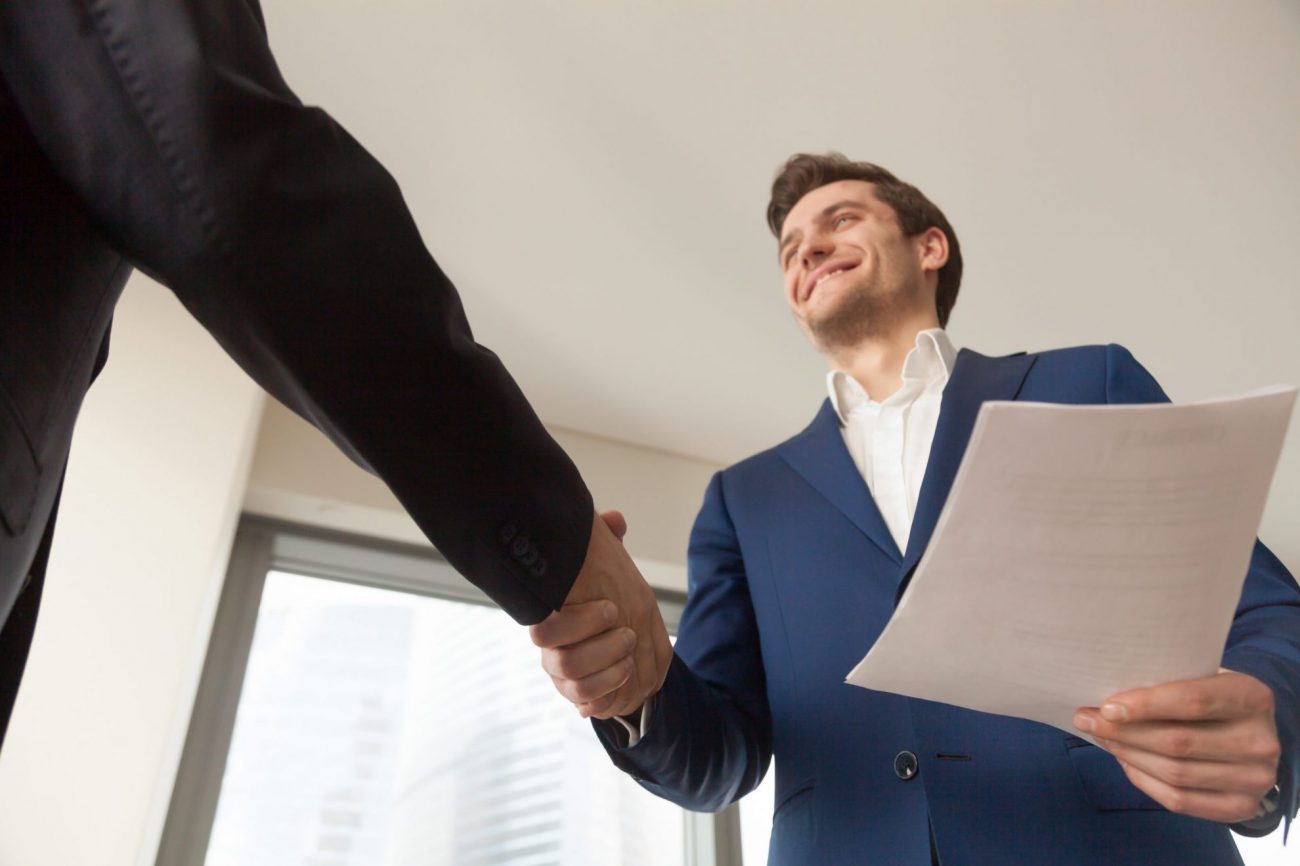 Image of two men shaking hands illustrates blog: "3 Ways to Improve the Candidate Experience"