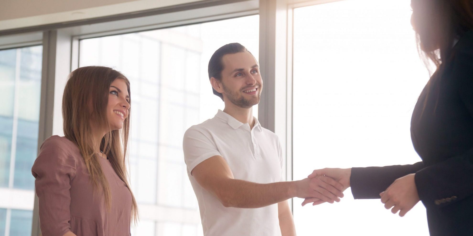 Photo of woman and man shaking hands illustrates blog: "Seasonal Hiring for the Holidays: What You Need to Know"