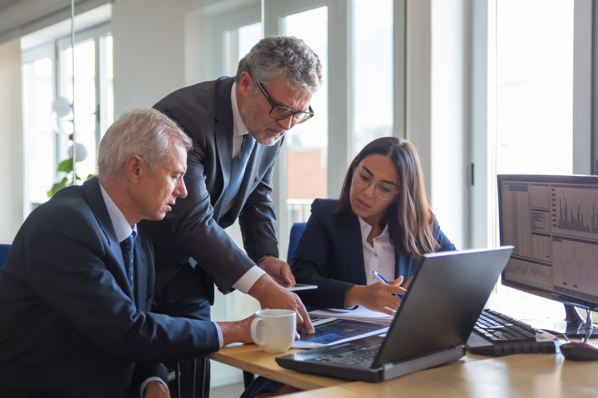 Photo of workers sitting at desk illustrates blog: "From the Great Resignation to the Great Retirement: the Job Trends You Need to Know"