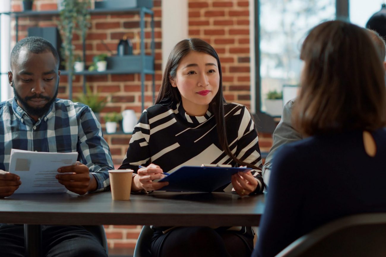 Photo of man and woman conducting job interview illustrates blog: "For How Long is a Background Check Good?"