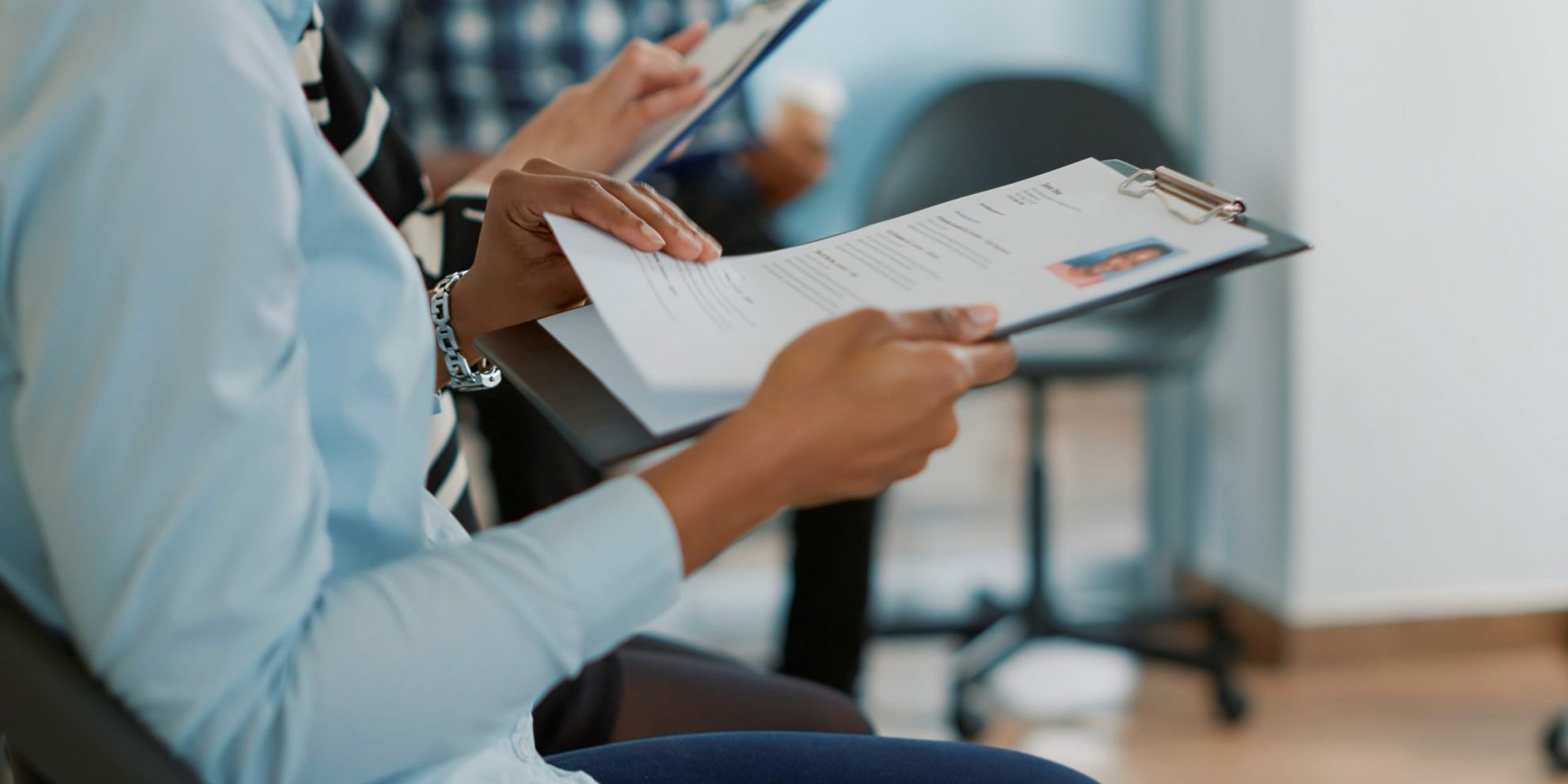 Photo of woman looking at resume illustrates blog: "Will Background Checks Show I Was Fired?"