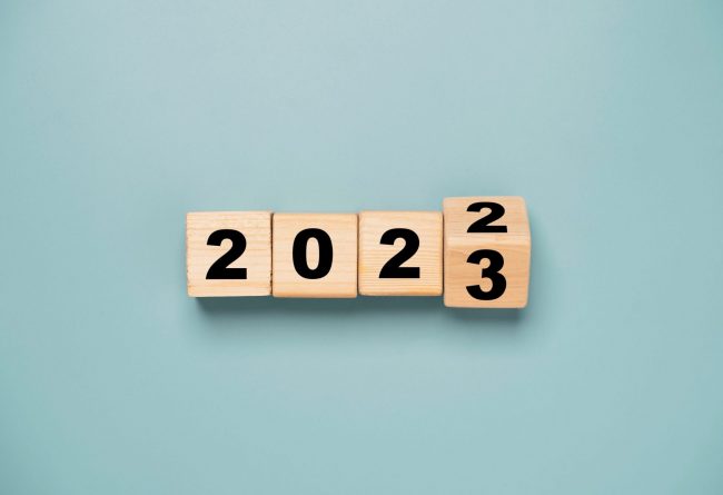 Wooden cubes that show the date changing from 2022 to 2023 illustrates blog: "4 Workplace Trends To Watch in 2023"