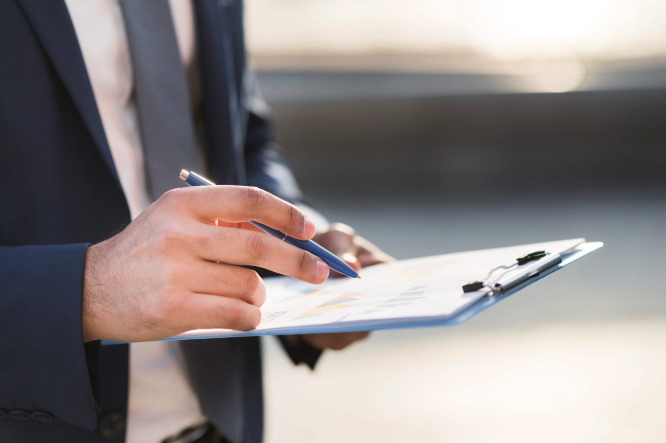 Photo of man holding clipboard illustrates blog: "Are Background Checks Confidential?"