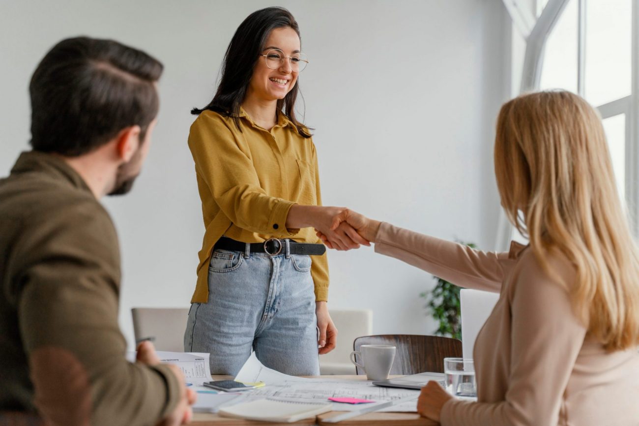 Photo of two women shaking hands illustrates blog "Background Check vs Resume: What Is the Difference?"