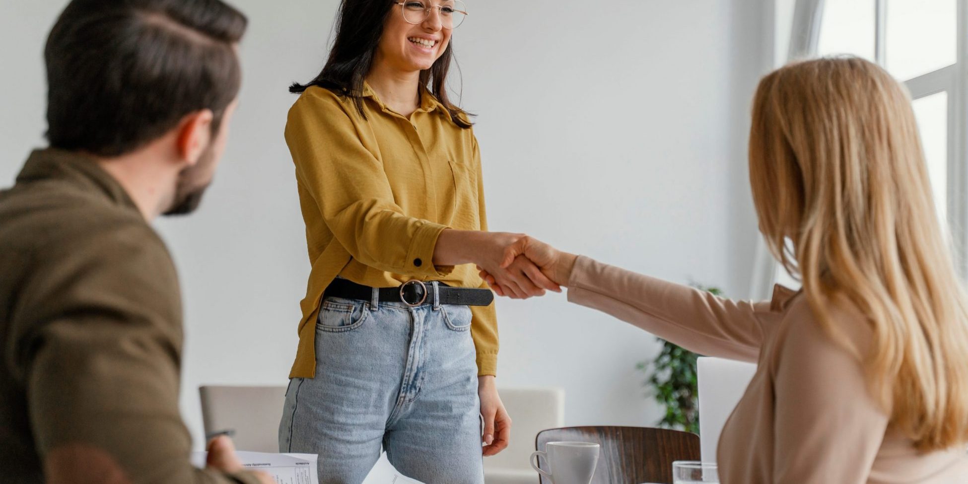 Photo of two women shaking hands illustrates blog "Background Check vs Resume: What Is the Difference?"