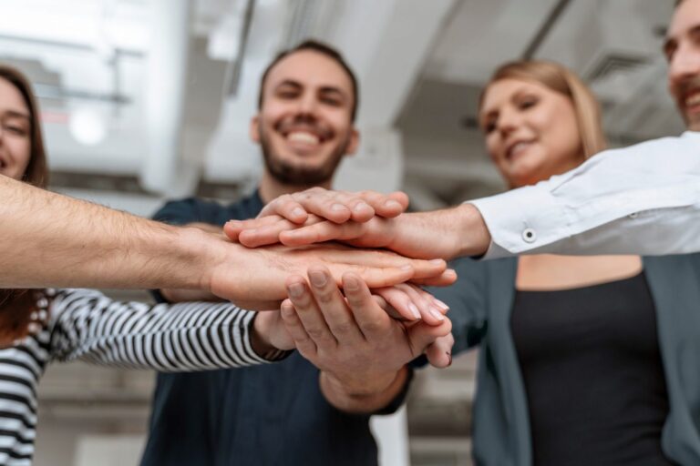 Group of people joining hands illustrates blog "5 Tips to Get Internal Hiring Right"