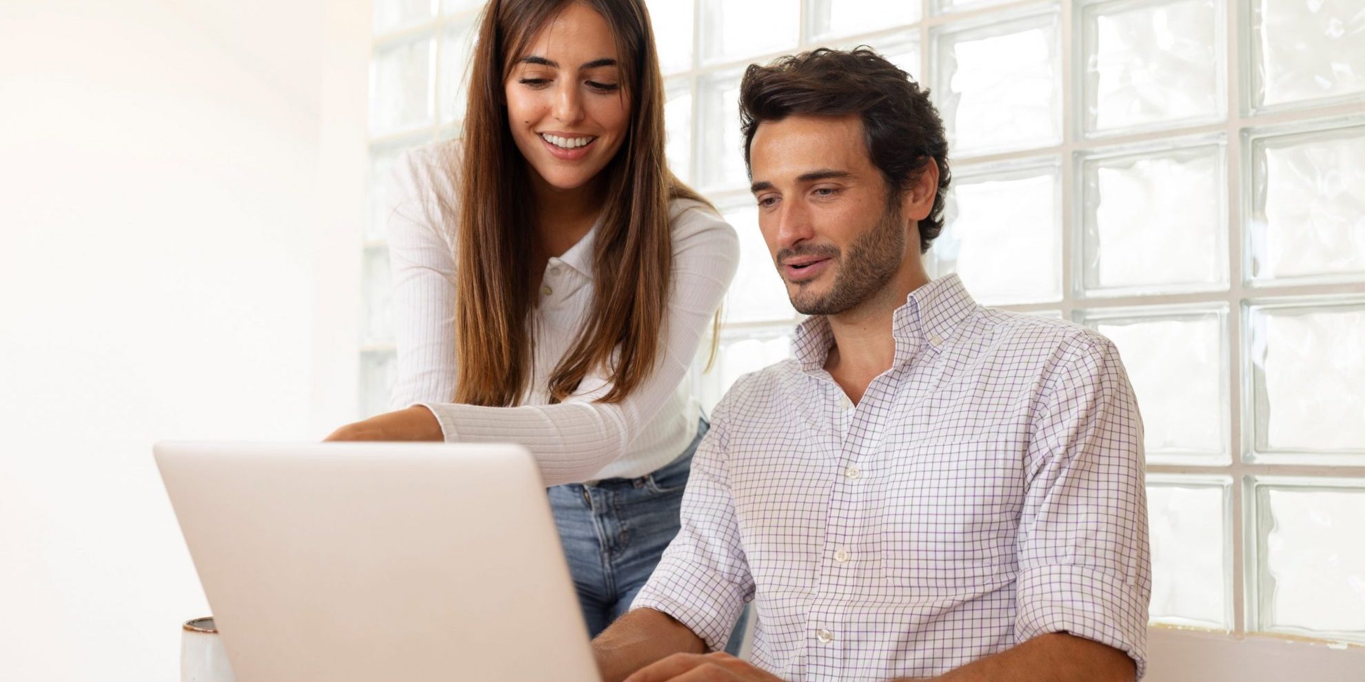 Woman and man looking at laptop illustrate blog "4 Ways Recruiters Can Use ChatGPT"