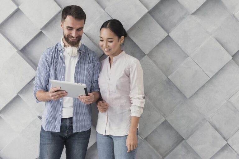 Man and woman looking at tablet illustrate blog "How to Evaluate a Candidate's Soft Skills"