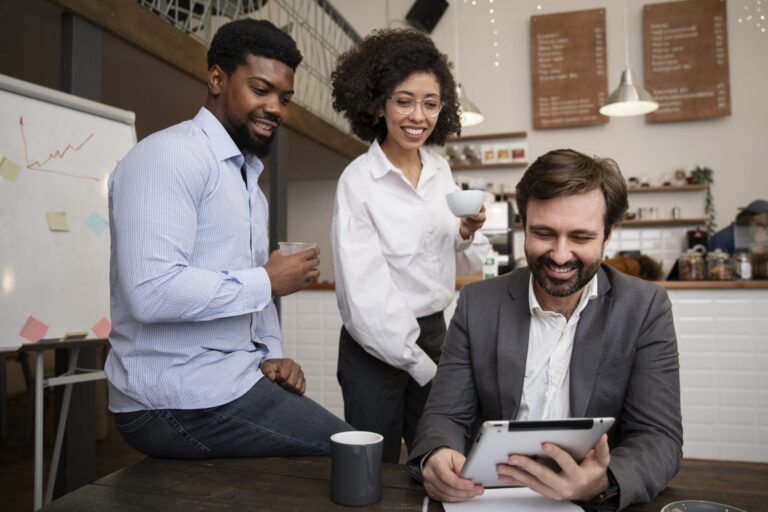 Group of three people looking at tablet illustrates blog "What Is DEI in the Workplace?"