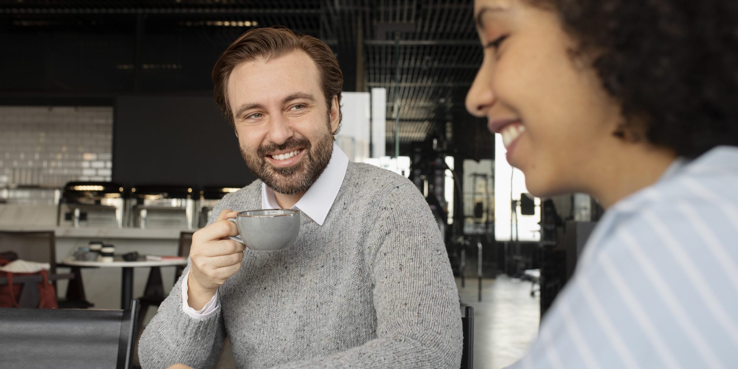 Two coworkers drinking coffee during break illustrate blog "Why Is Recruiting Everyone's Job?"