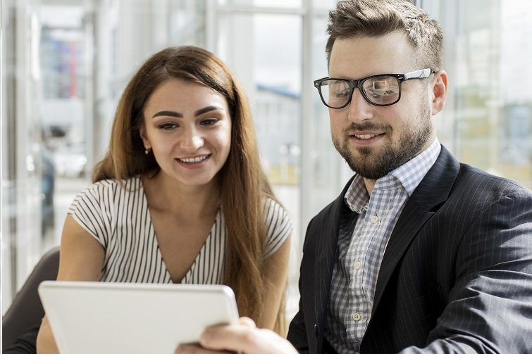 woman-man-tablet Woman and man looking at tablet illustrate blog "Background check vs Reference Check: "What Is the Difference?"